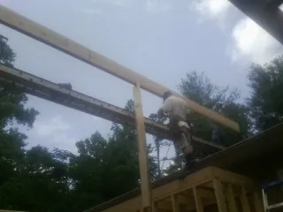 Carpenter setting a ridge beam over a new addition frame — Ice Dam Removal by Roofing Brothers in Prairie Village