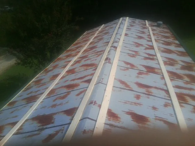 Rusted metal roof panels with new wood purlins before replacement — Storm Damage Roof Repair in Prairie Village by Roofing Brothers