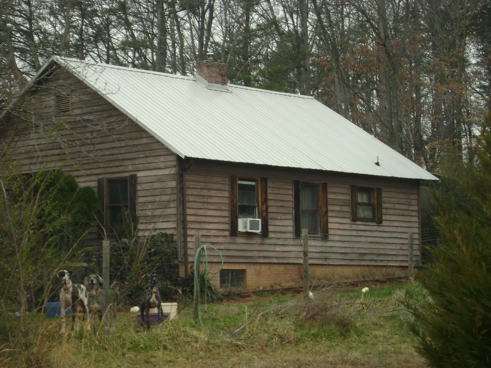 White metal roof on an old wood sided farmhouse, from a Asphalt Shingle Roof Repair job in Prairie Village